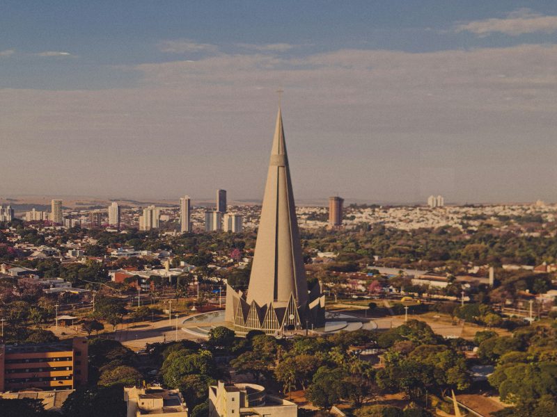 Stunning aerial view of Maringá Cathedral in Parana, Brazil, showcasing modern architecture amidst vibrant cityscape.
